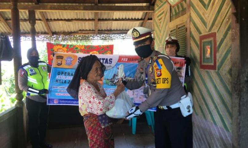 Kasat Lantas Polres Bengkulu Utara, AKP Kadek Suwantoro saat menyerahkan bantuan sembako ke warga. 