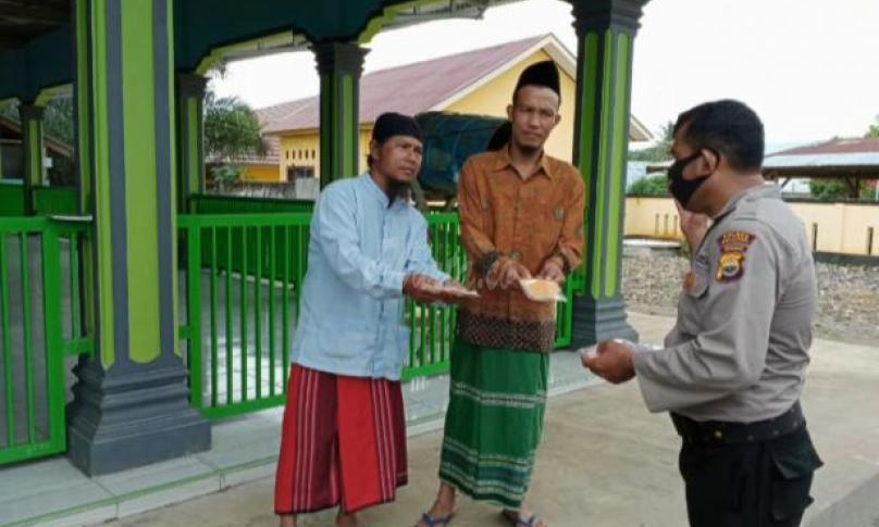 Sat Binmas Polres Seluma bagikan masker ke warga yang akan menunaikan sholat Jumat.