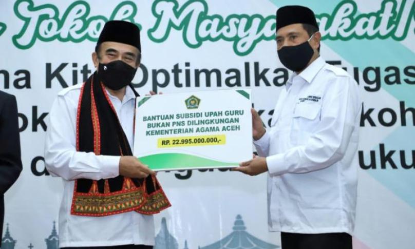 Menag menyerahkan bantuan secara simbolis kepada Kakanwil Kemenag Aceh (Foto: Rikie)