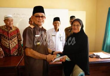 Asisten I Setda Bengkulu Selatan menyerahkan bantuan dan honorarium untuk dhuafa dan guru ngaji 