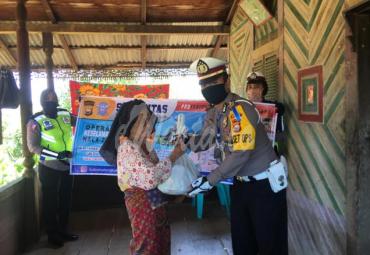 Kasat Lantas Polres Bengkulu Utara, AKP Kadek Suwantoro saat menyerahkan bantuan sembako ke warga. 