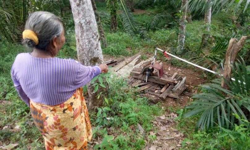 Marulia menunjukan lokasi hilangnya mesin pompa air miliknya kepada polisi