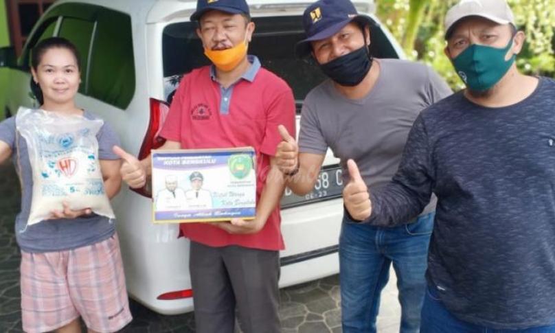 Plt Kadis PUPR Kota Bengkulu turun langsung ikut membagikan Rasmi ke warga.