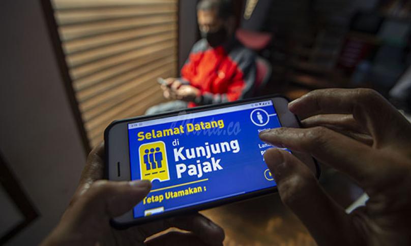 Warga mencari informasi tentang pajak di portal www.pajak.go.id dengan telepon pintarnya di Jakarta, Selasa (24/11/2020). (antarafoto)