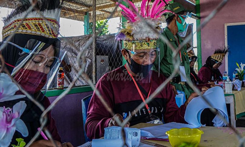 Sejumlah petugas KPPS mengenakan mahkota ciri khas Papua di Tempat Pemungutan Suara (TPS) 01, Kampung Wiantre (Arso V), Distrik Skanto, Kabupaten Keerom, Papua, Rabu (9/12/2020).- (antarafoto)