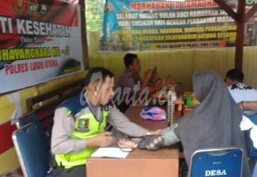 Petugas media dari tim dokkes Polres Lutra sedang mengecek kesehatan warga