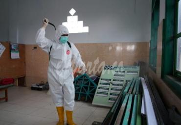 Foto petugas lakukan penyemprotan desinfektan di fasilitas umum.
