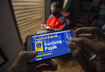 Warga mencari informasi tentang pajak di portal www.pajak.go.id dengan telepon pintarnya di Jakarta, Selasa (24/11/2020). (antarafoto)