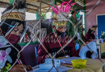 Sejumlah petugas KPPS mengenakan mahkota ciri khas Papua di Tempat Pemungutan Suara (TPS) 01, Kampung Wiantre (Arso V), Distrik Skanto, Kabupaten Keerom, Papua, Rabu (9/12/2020).- (antarafoto)