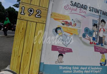 Warga berada di dekat mural stunting di Jakarta, Rabu (16/12/2020). - (antarafoto)